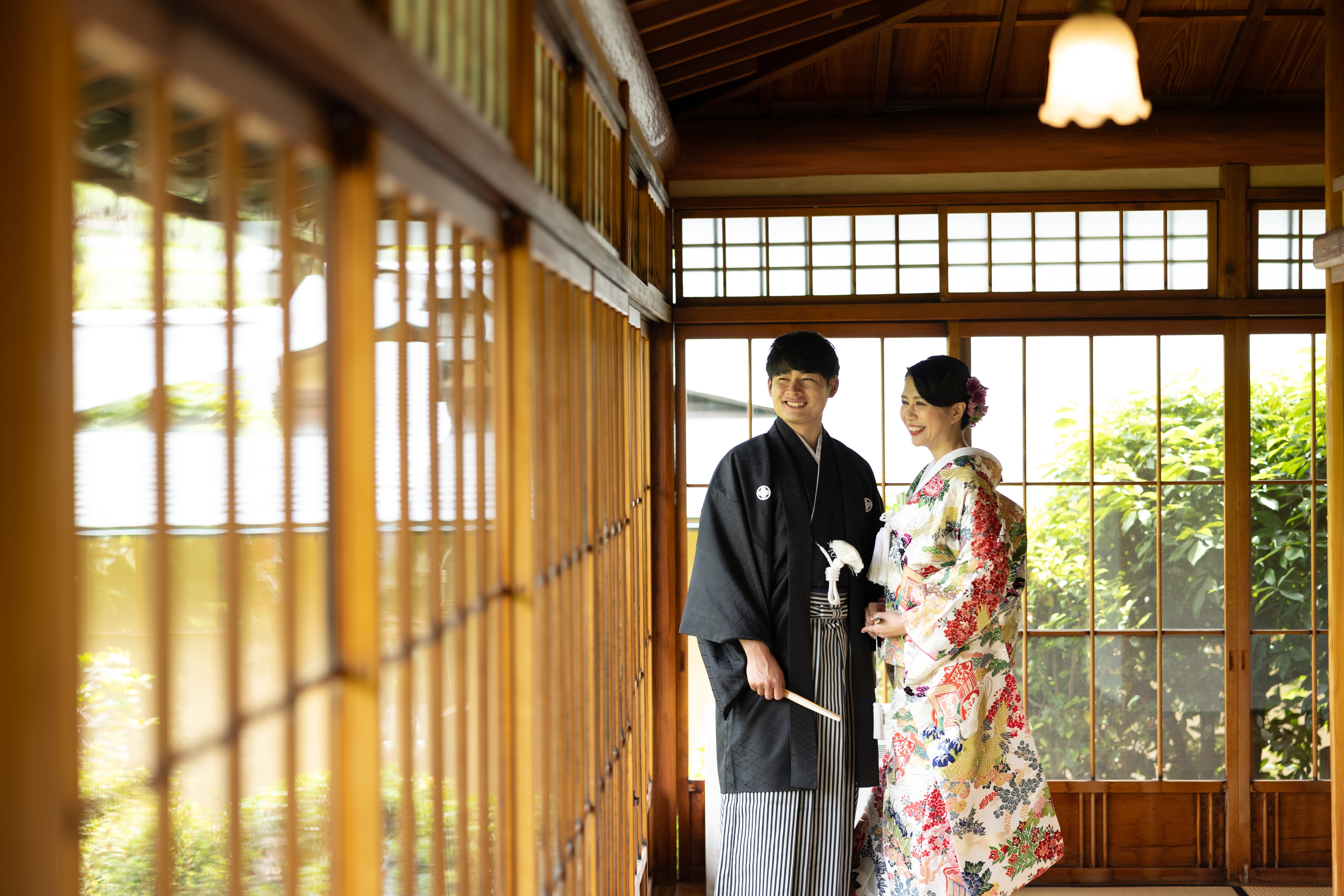 三養荘の回廊で微笑む和装の新郎新婦